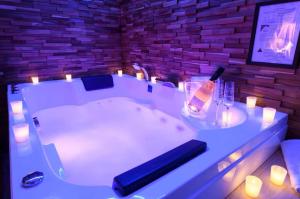 a bathroom with a bath tub with a bottle of champagne at Evasion à deux - Spa privatif in Beaugency