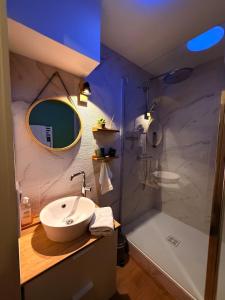 ein Badezimmer mit Waschbecken und Dusche in der Unterkunft Evasion à deux - Spa privatif in Beaugency