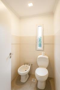 Departamento LUNA NUEVA في سانتا كلارا ديل مار: حمام أبيض مع مرحاض ومغسلة