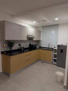 马斯喀特Al Azaiba apartment的一个带水槽和冰箱的大厨房 更多4张照片