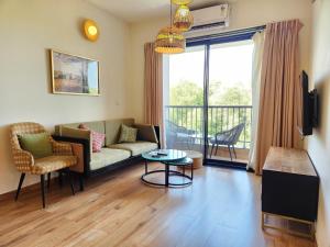 Warm 2BHK with Scenic Mangrove View in Candolim Goa في كاندوليم: غرفة معيشة مع أريكة وطاولة