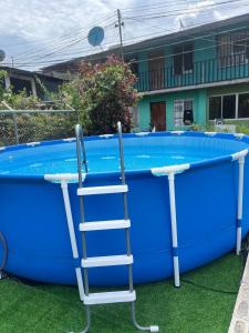 a ladder standing next to a large pool at Alba House with Pool in Puerto Jiménez