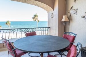 een eetkamer met een tafel en stoelen en de oceaan bij Sonoran Spa W404 in Campo del Medio