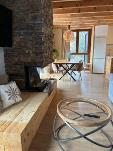 a living room with a fireplace and a table at Eth Estel de Salardú--Casa con vistas de ensueño-Fibra Optica,5TV in Salardú