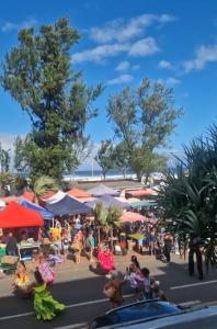 Una multitud de personas sentadas en una calle con paraguas. en Tara, en Saint-Pierre 4 fotos más