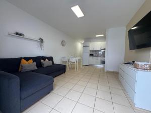 ein Wohnzimmer mit Sofa und eine Küche in der Unterkunft Parque Don José 189 in Arona