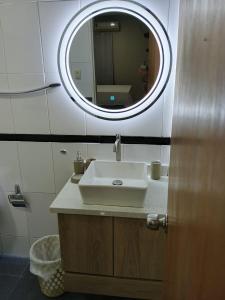 a bathroom with a sink and a mirror at Torre Imperial Apartamento in Maracay