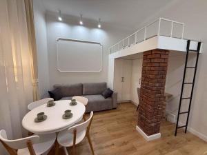 a living room with a loft bed and a table at Apartament Antresola in Kalisz