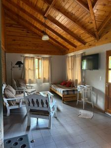 una sala de estar con una cama y un sofá en CABAÑAS AILIN-CO, en El Bolsón