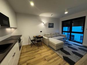 una sala de estar con un sofá y una mesa en Apartamenty Forestlive, en Międzychód