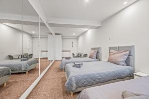 a bedroom with three beds and a mirror at Apartamenty Centrum in Rybnik