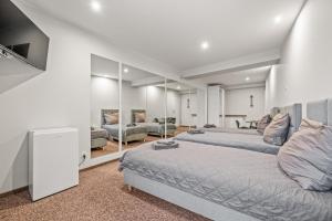 een slaapkamer met een groot bed en spiegels bij Apartamenty Centrum in Rybnik