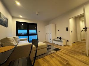 una sala de estar con un sofá y una mesa en Apartamenty Forestlive, en Międzychód