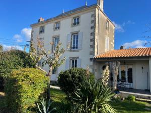 an old white building with a tower on top at Chez Guilem chambre rose in Saint-Maixent-lʼÉcole