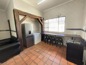 约翰内斯堡Bates Motel的厨房配有冰箱和一些椅子