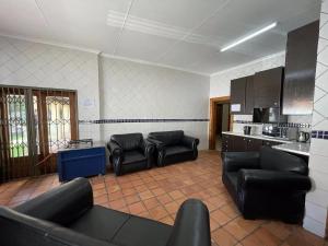 约翰内斯堡Bates Motel的一间带黑色家具的客厅和一间厨房