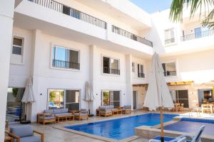 a pool at a hotel with chairs and umbrellas at Family Nexus Hotel - Carefree in Hurghada