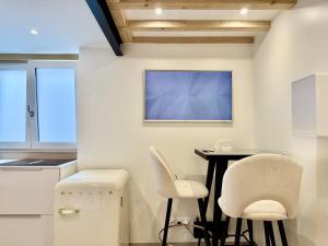 eine Küche mit einem Tisch und zwei weißen Stühlen in der Unterkunft Golden Prestige Serenity & Elegance in Chenôve + 35 Fotos