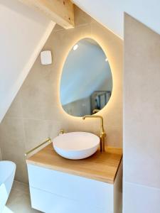 ein Badezimmer mit einem Waschbecken und einem Spiegel in der Unterkunft Golden Prestige Serenity & Elegance in Chenôve