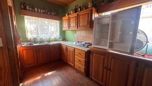 uma cozinha com armários de madeira e uma grande janela em Sabie Gypsy's Backpackers em Sabie