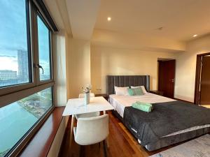 sypialnia z łóżkiem, stołem i oknem w obiekcie Seaview stay at Cinnamon Life Residence - City of Dreams w Kolombo +3 zdjęcia