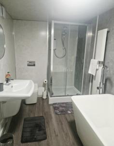 a bathroom with a shower and a sink and a toilet at King Edward 3 bed house ideal for contractors in Darlaston +28 photos
