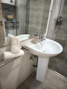 une salle de bain blanche avec lavabo et douche dans l'établissement Golf & Playa a 1 min, à Grao de Castellón