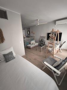 une chambre avec un lit et des chaises dans une pièce dans l'établissement Golf & Playa a 1 min, à Grao de Castellón