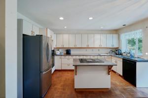 a kitchen with a black refrigerator and white cabinets at The Coastal Garden Retreat in Delta