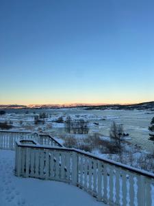 a snow covered balcony with a view of the water at Exclusive villa by the sea, close to Saltstraumen in Bodø +2 photos