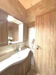 a bathroom with a sink and a mirror at Theo apartment with Balcony in Marathias