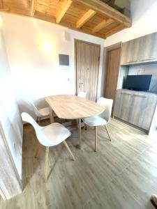 a dining room with a wooden table and white chairs at Theo apartment with Balcony in Marathias