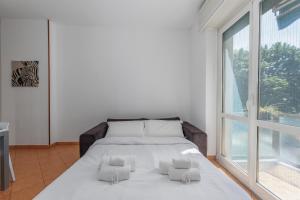 una cama en una habitación con una ventana grande en Easy Parking - Air Conditioning - Balcony - Quiet, en Cinisello Balsamo