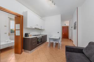 Una cocina y una sala de estar con un sofá y una mesa. en Easy Parking - Air Conditioning - Balcony - Quiet, en Cinisello Balsamo