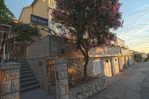 um edifício com uma árvore ao lado em Villa Marinesa em Hvar