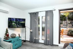 a living room with a tv and a sliding glass door at Harmonia in Athens