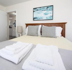a white bed with two white towels on it at 508 A The Shore Break Cottage in Virginia Beach