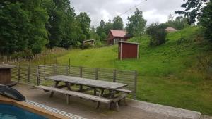 Una terraza de madera con una mesa de picnic al lado de un patio. en Vara Hemma, en Smedamåla