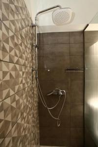 a shower with a hose attached to a tiled wall at Harmonia in Athens +36 photos