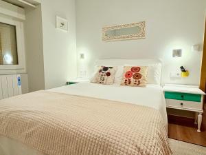 a bedroom with a white bed with two pillows at Casa CAMPELO- Playas de Pinténs - CANGAS-HIO- Ría de Aldán in Cangas de Morrazo
