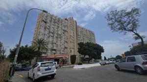 a large building with cars parked in a parking lot at Estudio III VISTAS MAR, TREN Y MALAGA in Torremolinos