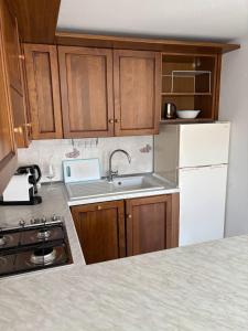 a kitchen with wooden cabinets and a white refrigerator at Villa Hanna in Villa Faraldi +24 photos