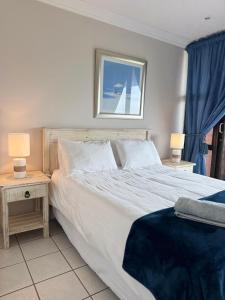 a bedroom with a large bed and two night stands at De Reyge in Jeffreys Bay