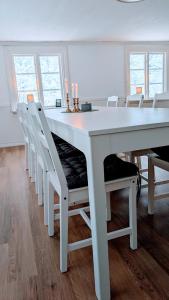 einen weißen Esstisch und Stühle mit Kerzen drauf in der Unterkunft Historisches Schwedenhaus, 25m zum Wasser im Garten, ideal zum Angeln, 8 Personen in Fur