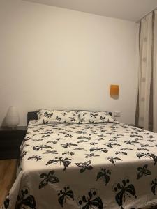una camera da letto con un letto con un piumone bianco e nero di Apartament Centru a Craiova