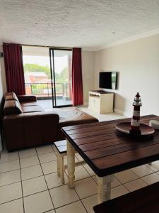 a living room with a couch and a table at De Reyge in Jeffreys Bay