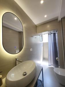 a bathroom with a white sink and a mirror at Feel like home 2 in Shkodër +26 photos
