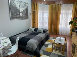 a bedroom with a bed and a table and a chair at La casita de Lukas in Sabero