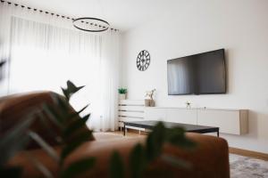 a living room with a tv and a couch at Una Lux Apartment in Sombor