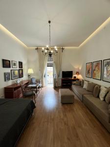 Una sala de estar con un sofá y un televisor en Apartment Ksenija, en Belgrado